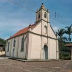 an old church with a red roof and a blue door